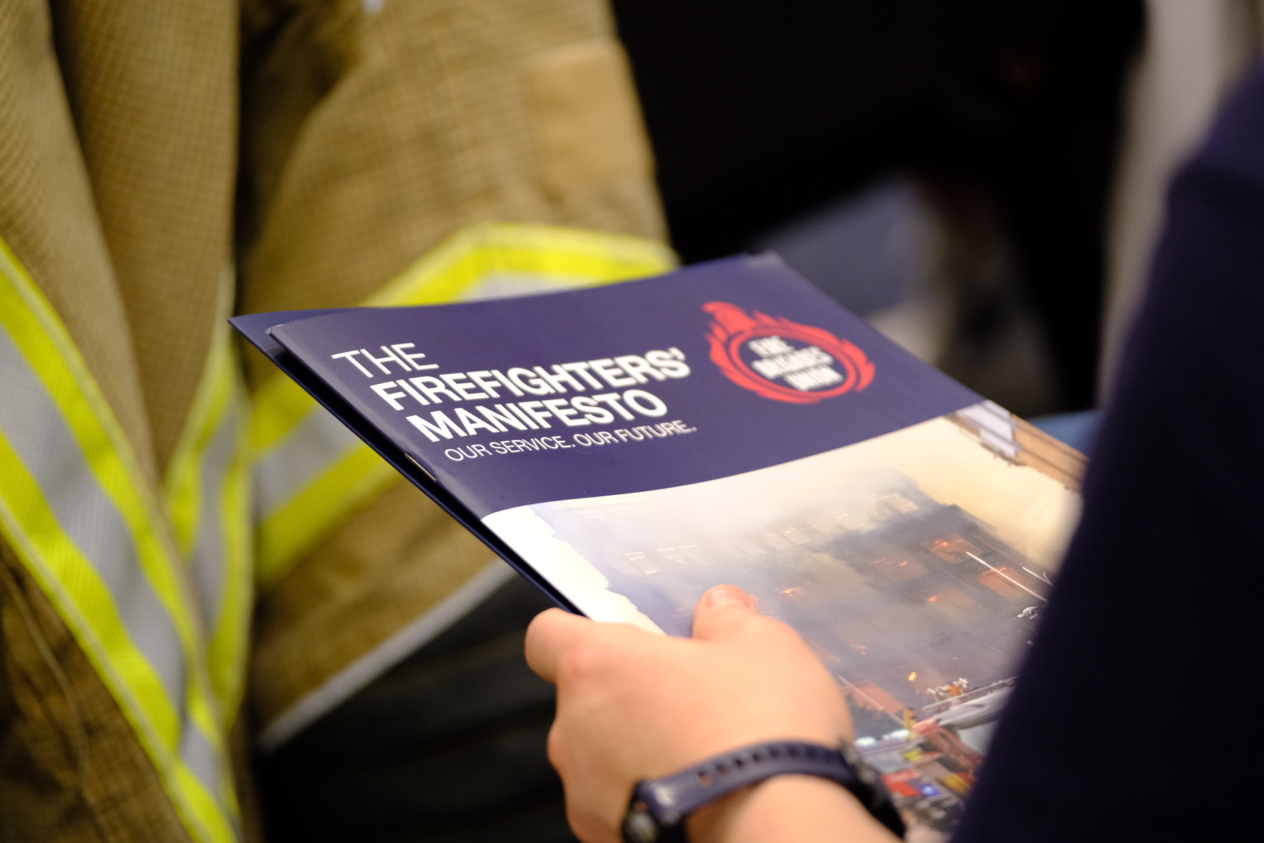 Someone holding a booklet titled The Firefighters Manifesto