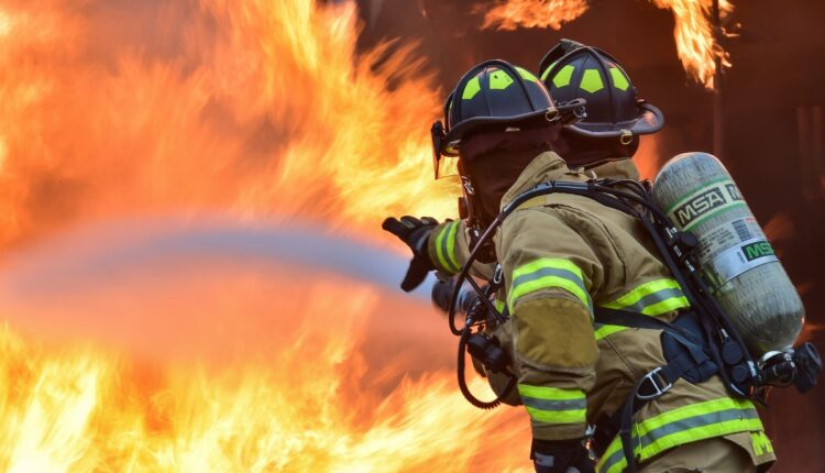 Two Firefighters tackle blaze with hose