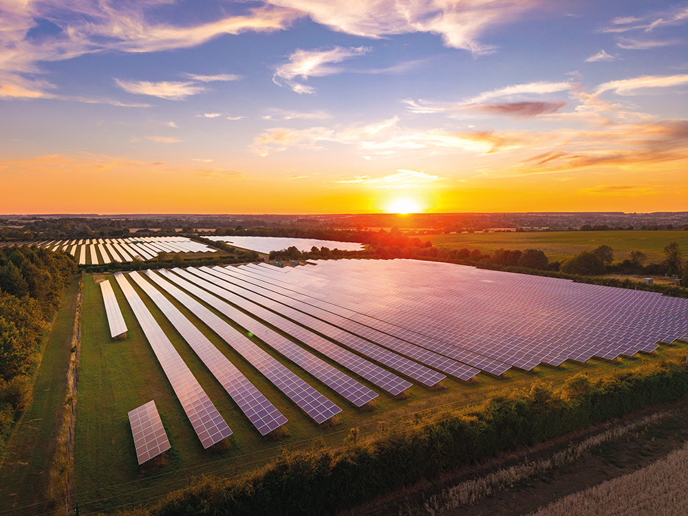 Aerial view of a solar farm at sunset, providing sustainable energy