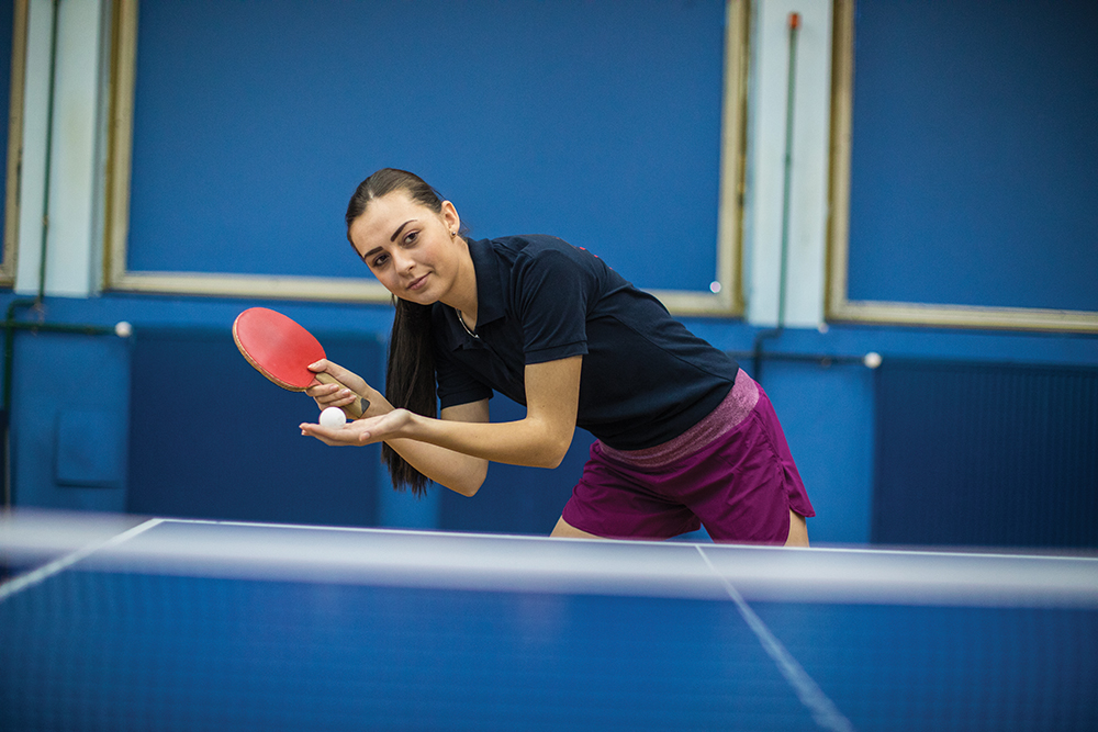 young woman playing table tennis indoors
